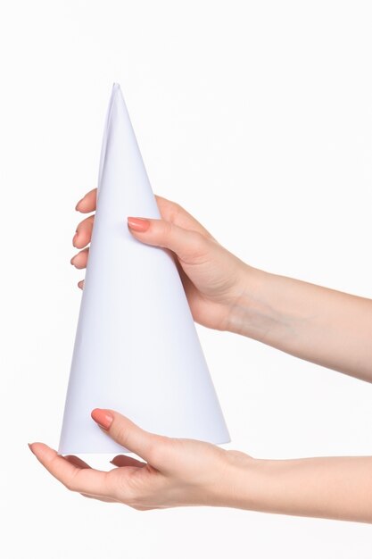 The white cone of the props in the female hands on white with  right shadow