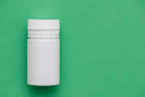 Free photo white container on green background