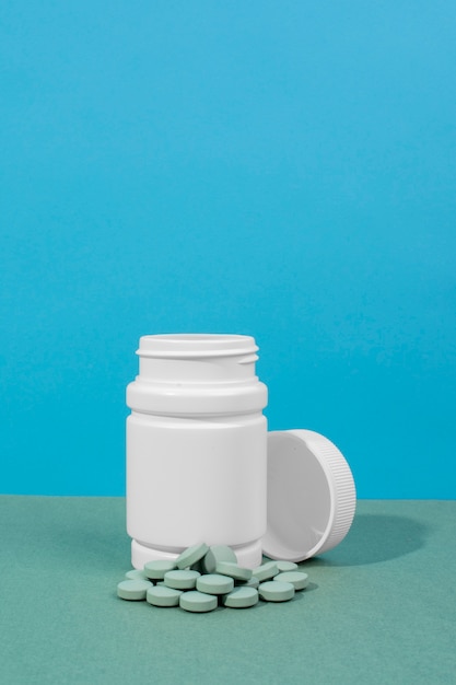 White container with green pills