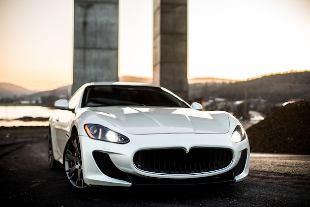 Free photo white coupe sport car standing on the road, front view.