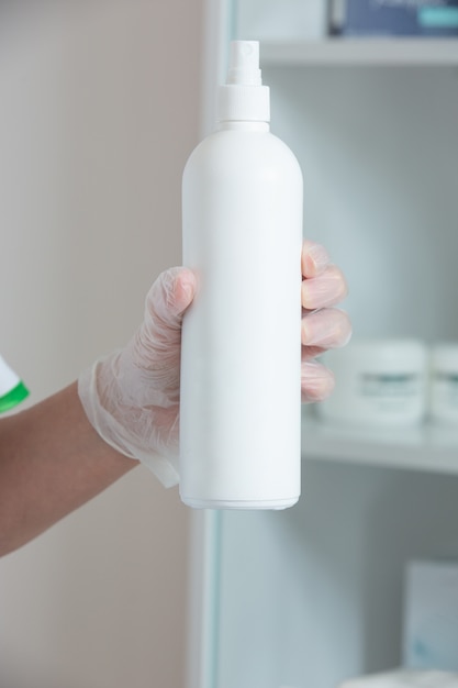 Free photo white cream bottle in hand