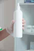 Free photo white cream bottle in hand