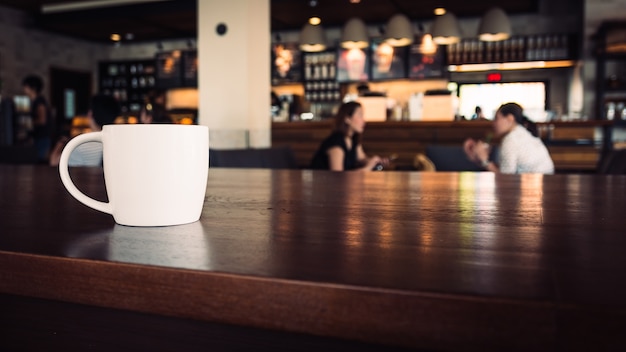 木製の表面上のコーヒーの白いカップ