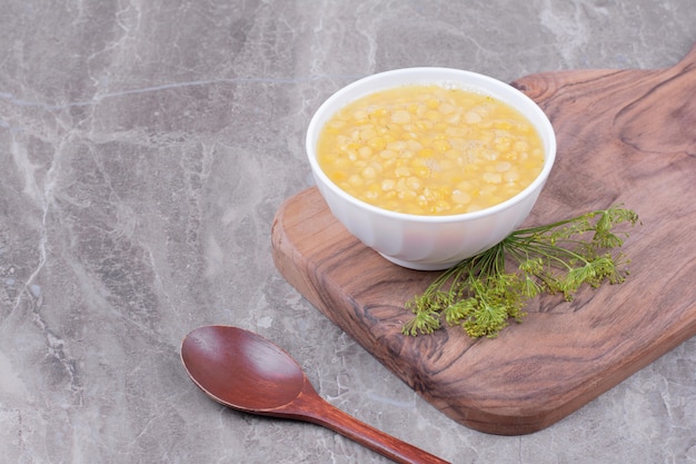 Белая чашка супа из гороховой фасоли на деревянном блюде