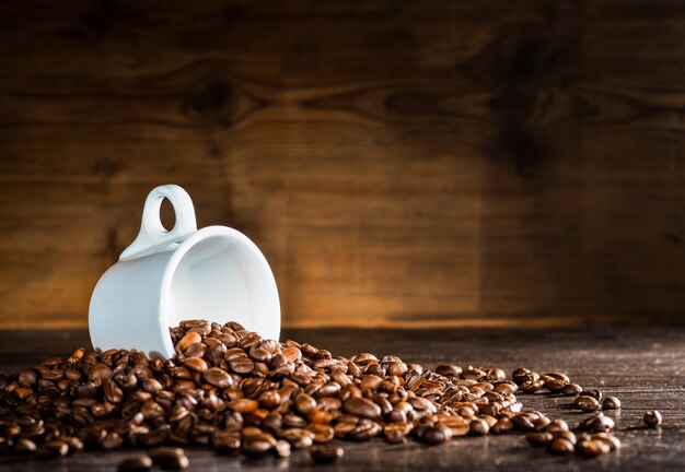 White cup surrounded by coffee beans
