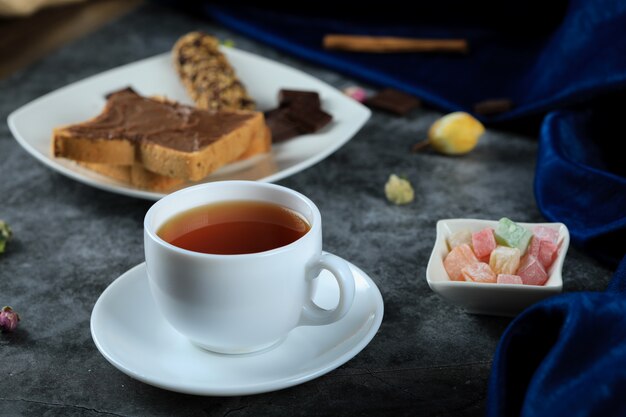 A white cup of tea with chocolate toast bread