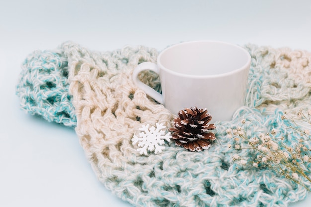 Foto gratuita tazza bianca con sciarpa a maglia
