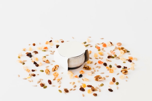 White cup for yogurt between nuts and raisins