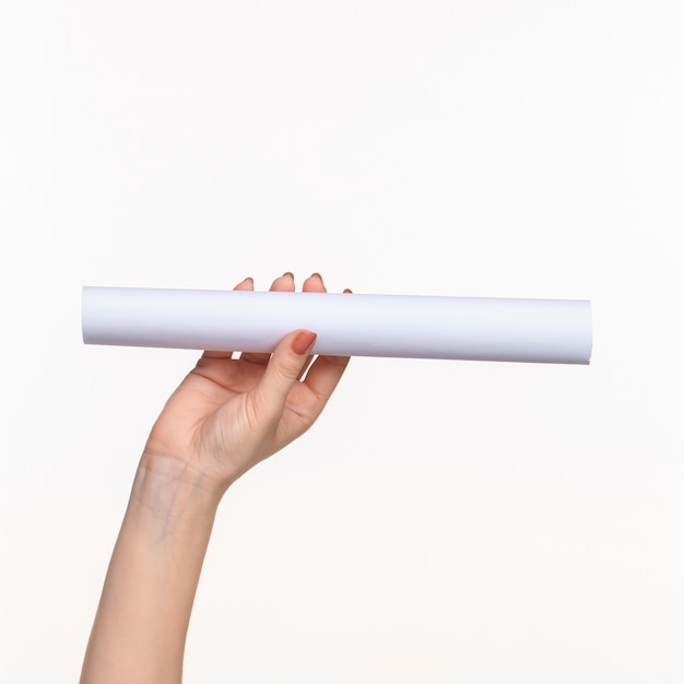 Free photo white cylinder of the props in the female hands on white background
