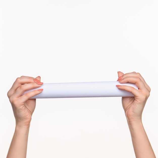 The white cylinder of the props in the female hands on white with  right shadow