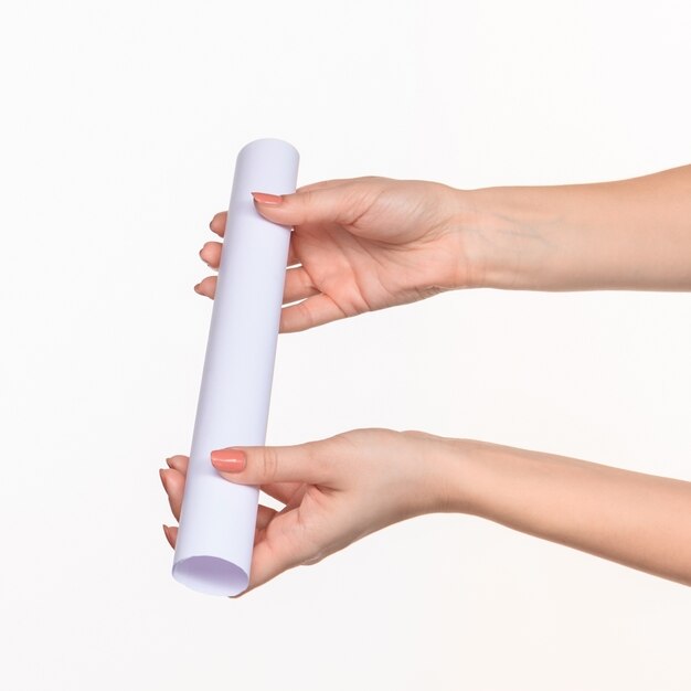 white cylinder of props in female hands on white with right shadow