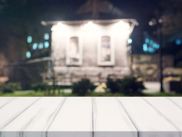 White desk in front of blur house at night