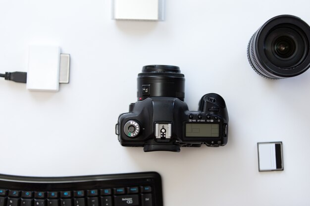 White desk with a professional camera and accessoires