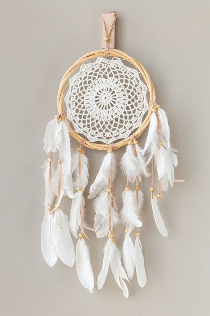 White dream catcher hanging on a off white wall