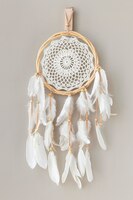 white dream catcher hanging on a off white wall