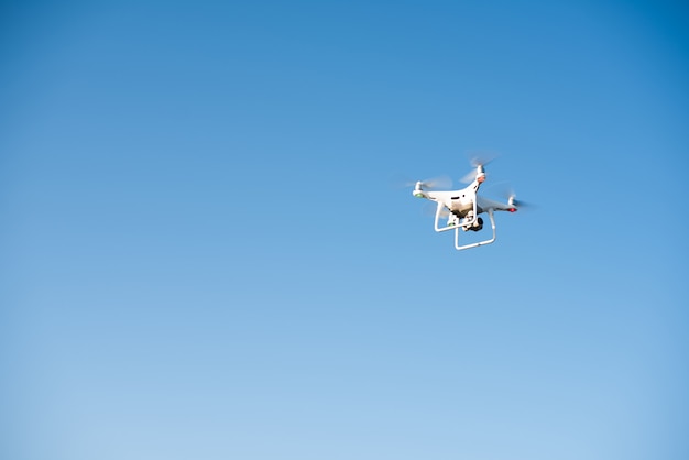 White drone fly in the sky recording a video