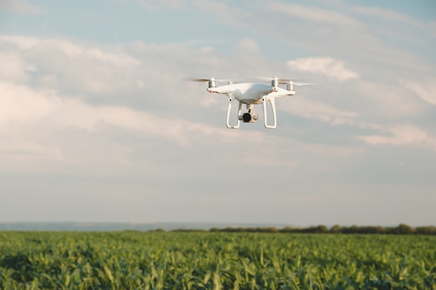 White drone hovering in a bright blue sky