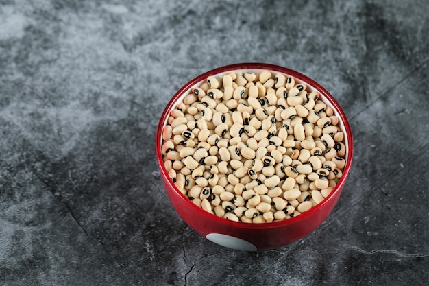 White dry beans in a red bowl