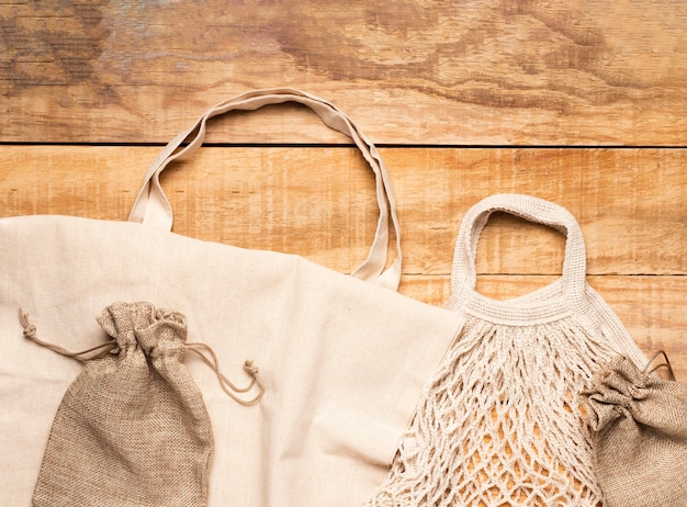 White eco friendly bags on wooden background