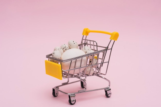 White eggs in grocery cart on table