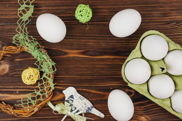 Белые яйца в стойке с маленькими шариками на столе