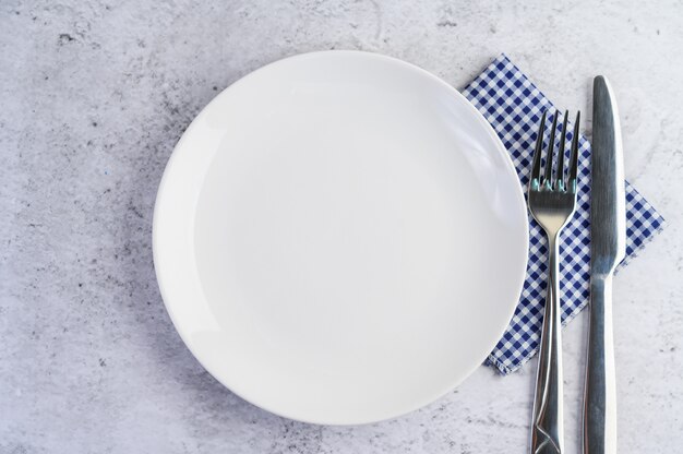 青白のテーブルクロスにナイフとフォークの白い空の皿。