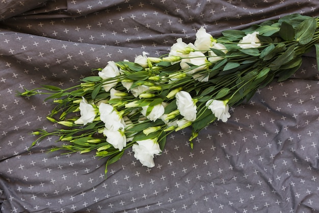 White eustoma bouquet on gray design textile