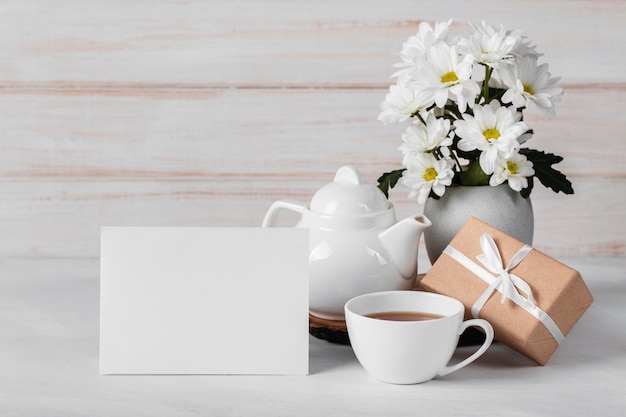 White flowers assortment with empty card and tea