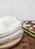 Foto gratuita fiori bianchi e asciugamani accatastati sul vassoio in legno