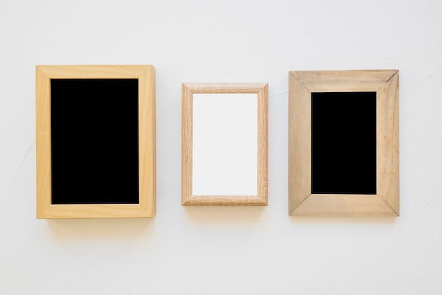 White frame between the black frames on wall