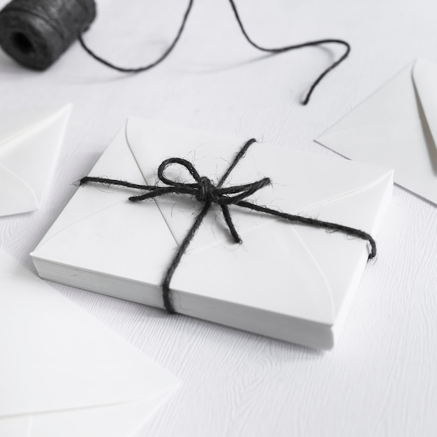 White gift box tied with black string on white background