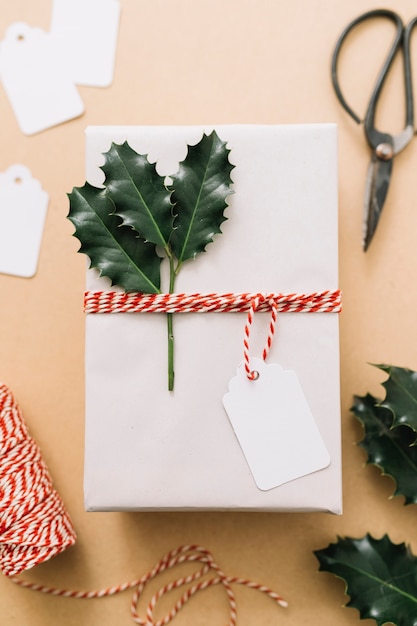 White gift box with green leaflets on table