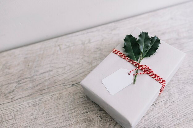 White gift box with leaflets on wooden table