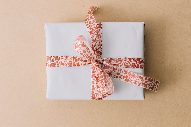 White gift box with ribbon on brown table