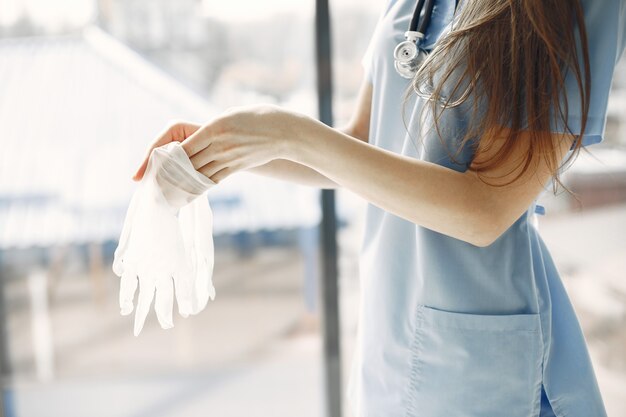 White gloves. Female doctor. Woman by window