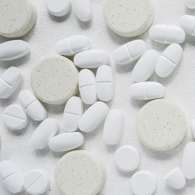Белые и серые таблетки на белом фоне