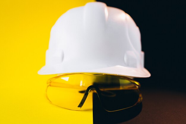 White hard hat with protection eyeglasses isolated 