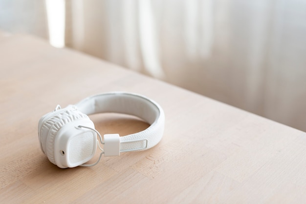 Free photo white headphones placed on table