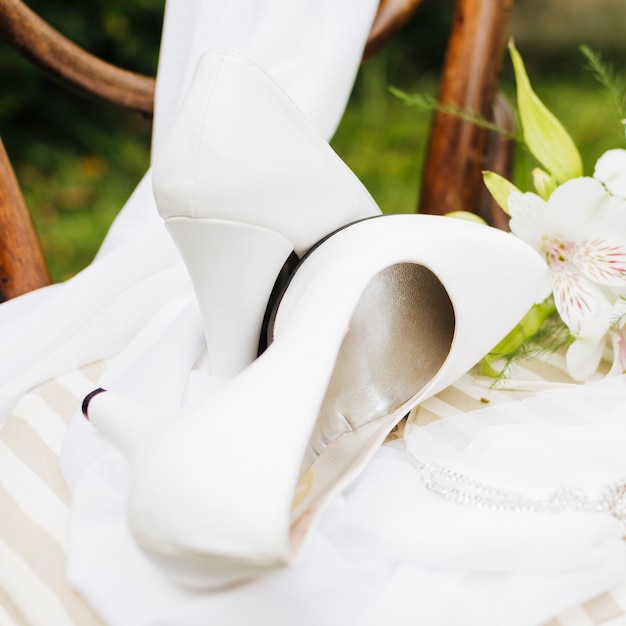 White high heels over the scarf on white table