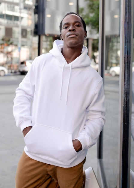 White hoodie on man with brown pants in the city