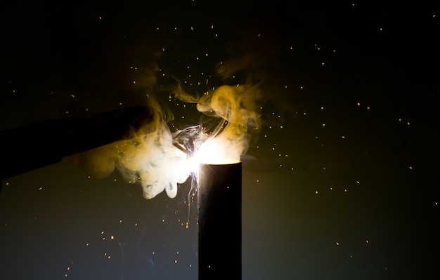 鋼材を研削する際に白い熱い火花と白い煙