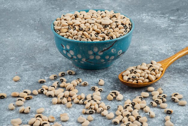 White kidney beans in blue bowl with spoon.