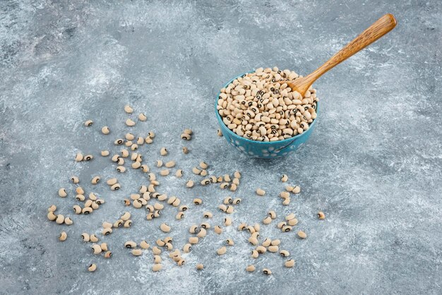 Foto gratuita fagioli bianchi in ciotola blu con cucchiaio.