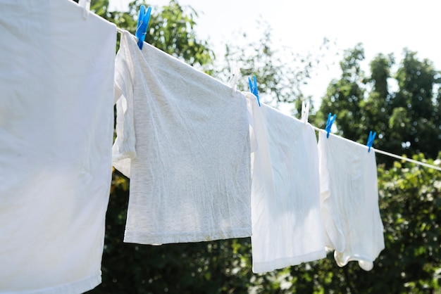 Foto gratuita lavanderia bianca che appende su una corda all'aperto
