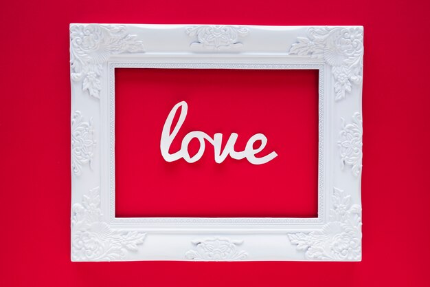 White Love inscription in frame on red table