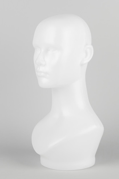 灰色の背景にプロファイルの白いマネキンの頭