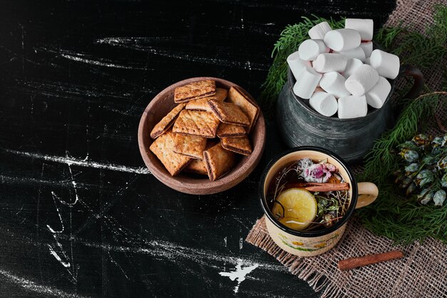 White marshmallows with crackers and a cup of drink.