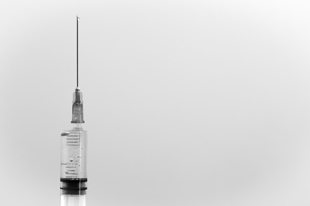 White medical syringe with a drop, isolated on white