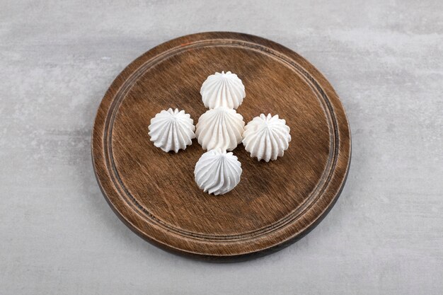 White meringue on a board, on the marble table. 