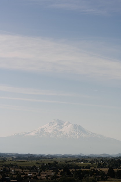 澄んだ空の下で町の近くの白い山